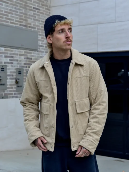 Hombre con casaca corduroy beige polo negro con gorra negra
