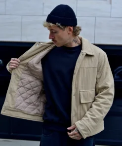 Hombre con casaca corduroy beige polo negro con gorra negra enseña forro casaca