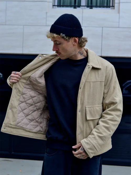 Hombre con casaca corduroy beige polo negro con gorra negra enseña forro casaca